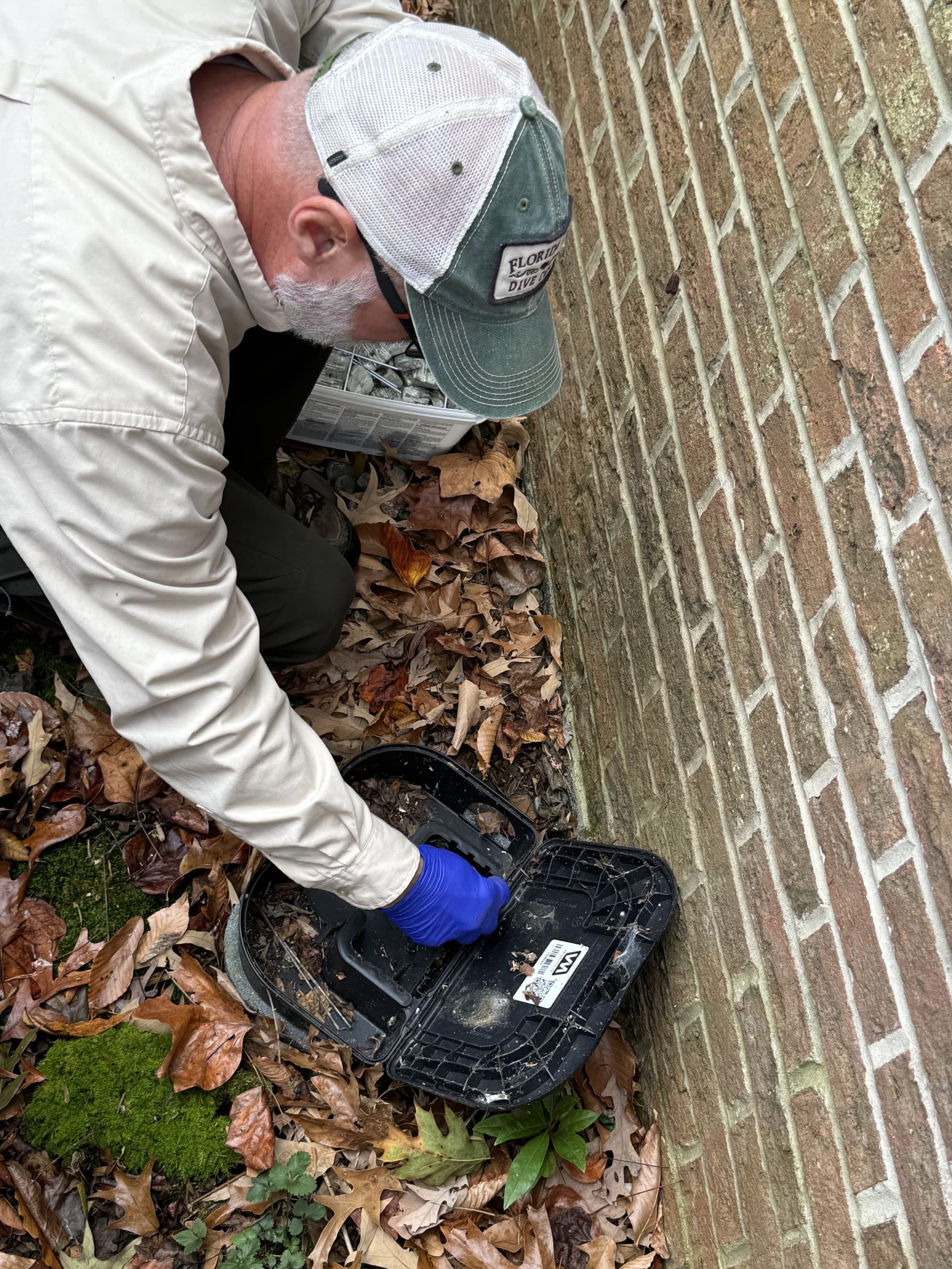 Close-up of a rodent bait station being serviced