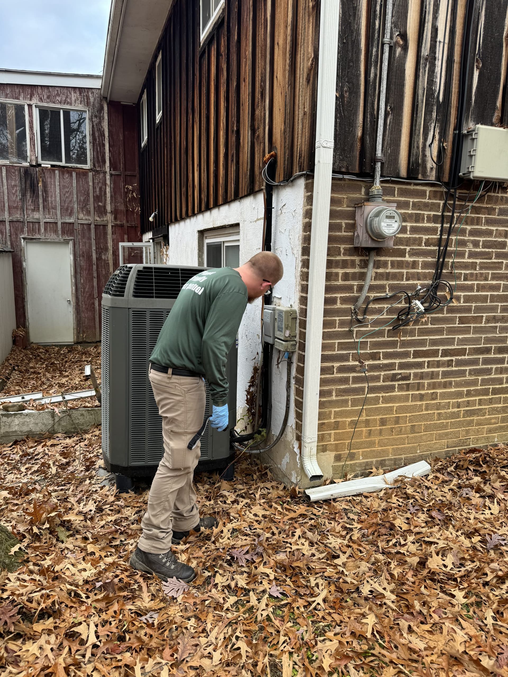A Planet Friendly technician inspecting a home exterior