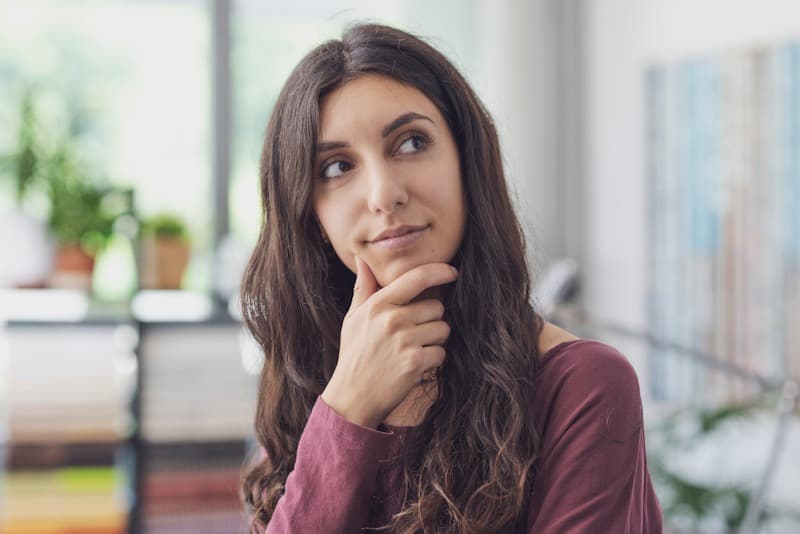 happy-woman-thinking-with-hand-on-chin-